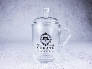 clear glass tea cup with curate essentials logo
